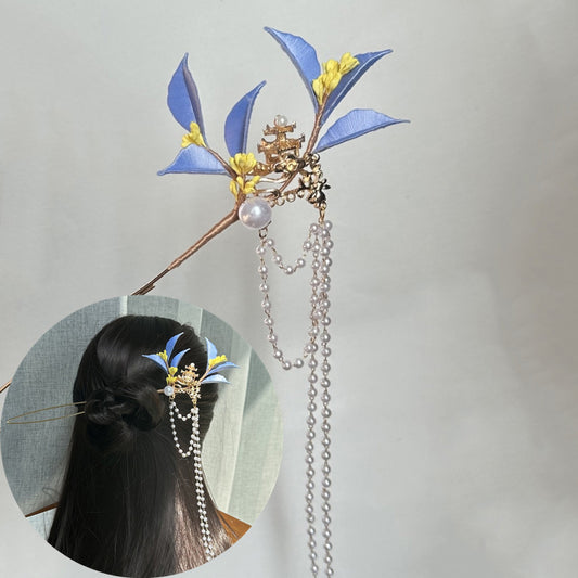 A finished handmade blue and yellow fabric flower hairpin with cascading pearl chains, shown in two views—a close-up and a smaller inset of it styled in a person's dark hair.