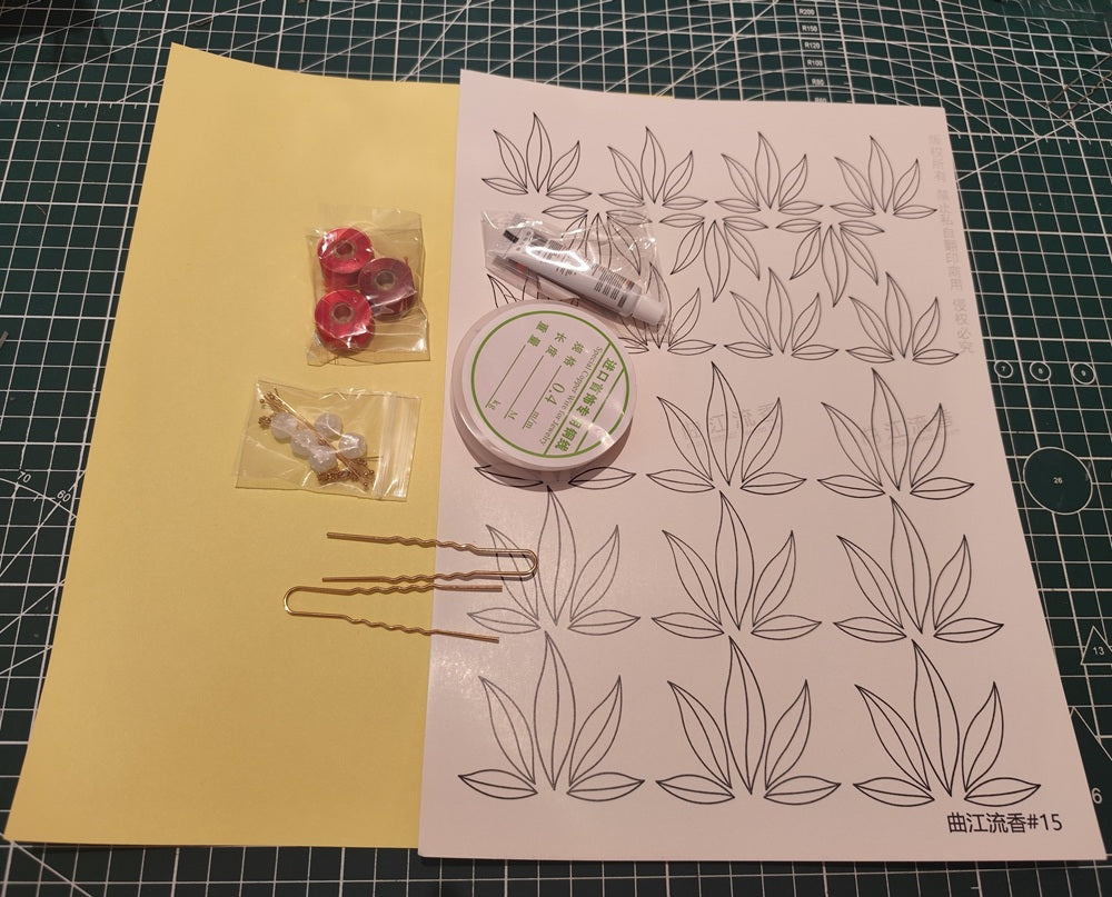 Maple leaf hairpin DIY kit with materials and a template on a green cutting mat.