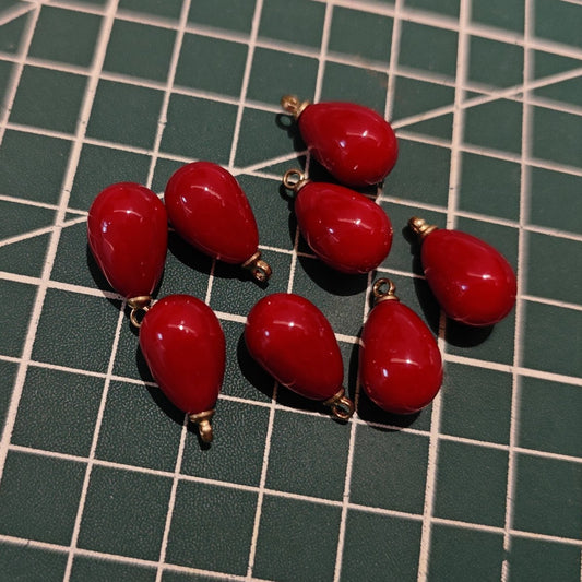 Group of glossy Angola Red plastic teardrop charms with gold-tone loops for DIY supplies.