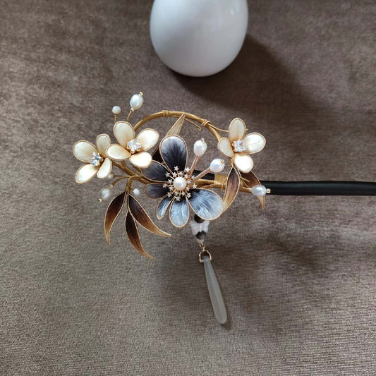 Close-up of delicate blue and white Ronghua silk velvet flowers with gold wire and pearl details on Chinese hairpin