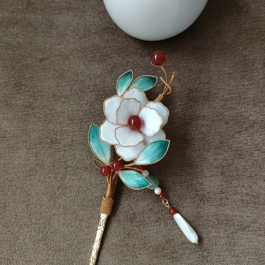 Close-up of delicate white camellia Ronghua velvet petals and gold accents on traditional Chinese hairpin