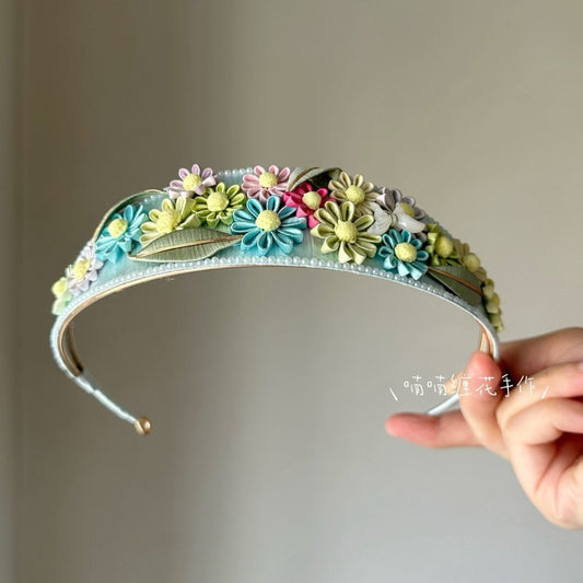 3D thread-wrapped floral crown with artisanal daisies and pearl accents made using traditional Chanhua techniques.