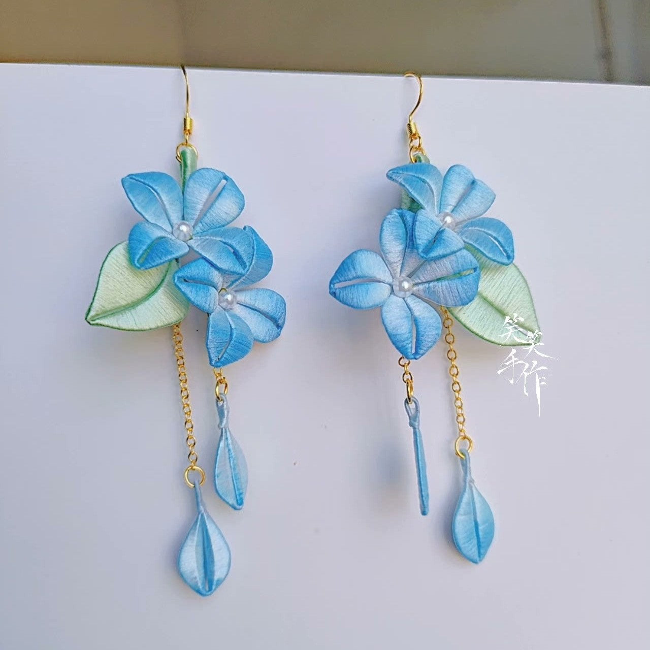 Beautiful artisan blue floral earrings with sterling silver hooks, showcasing intricate design and long dangle style for women.