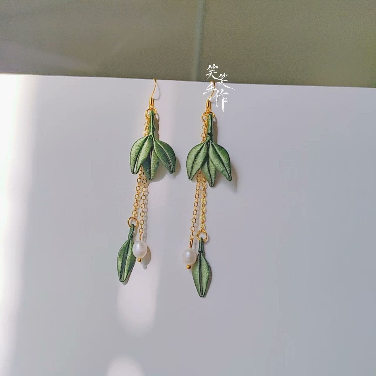 Elegant long dangle earrings, handmade with intricate green embroidery and white natural pearls, ideal for daily wear or special occasions.