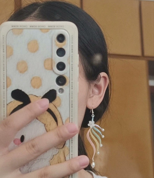 A close-up side view of a person wearing one of the handmade Chanhua silk tassel earrings, showing how it hangs gracefully.