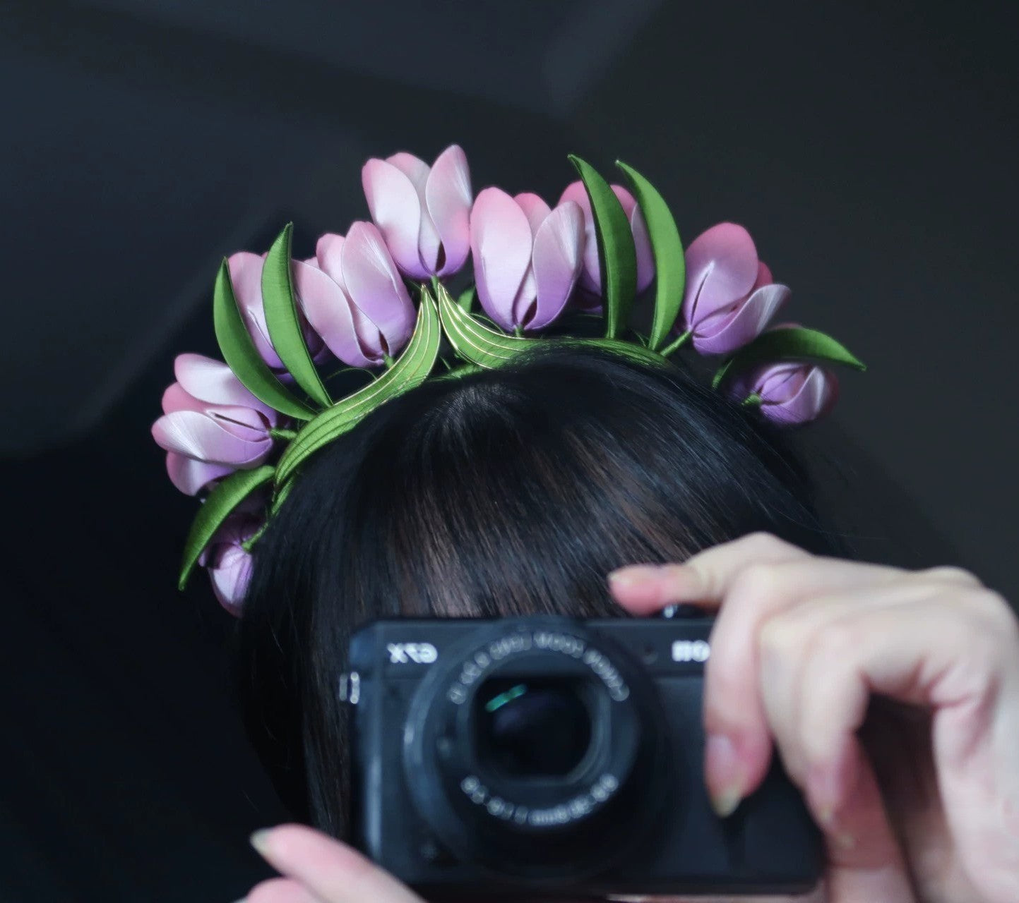 Overhead view of a handcrafted velvet tulip flower crown on dark hair, showcasing the pure handmade velvet petals and green leaf accents.