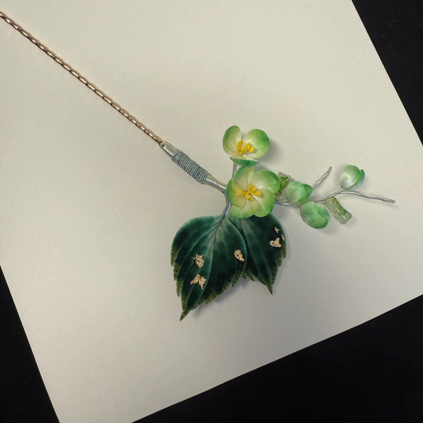 Handmade Ronghua green and white flower hair stick with deep green silk leaves and gold accents, full view