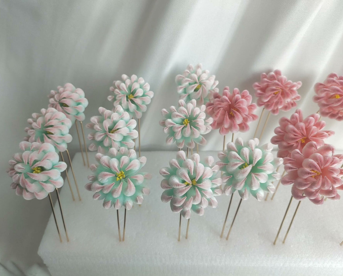 Handmade Ronghua pastel chrysanthemum hairpins in mint-pink and soft pink mulberry silk velvet flower, arranged on light background