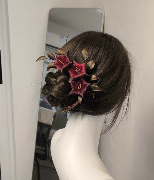 Close-up of deep red Ronghua silk datura flowers with golden-brown leaves and curling tendrils