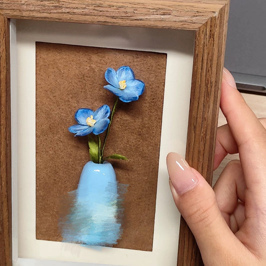 Close-up of delicate sky-blue Ronghua silk star flowers in tiny ceramic vase