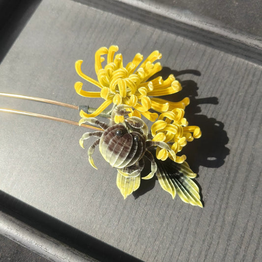 Handmade Ronghua chrysanthemum crab hairpin with yellow silk flower and black crab detail on dark tray