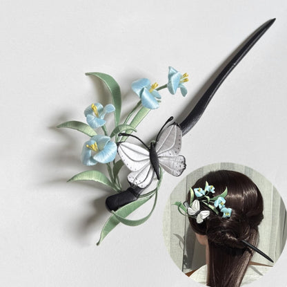 A finished handmade Chanhua hairpin featuring light-blue silk flowers, green leaves, and a white butterfly. An inset image shows the hairpin elegantly worn in a woman's hair.