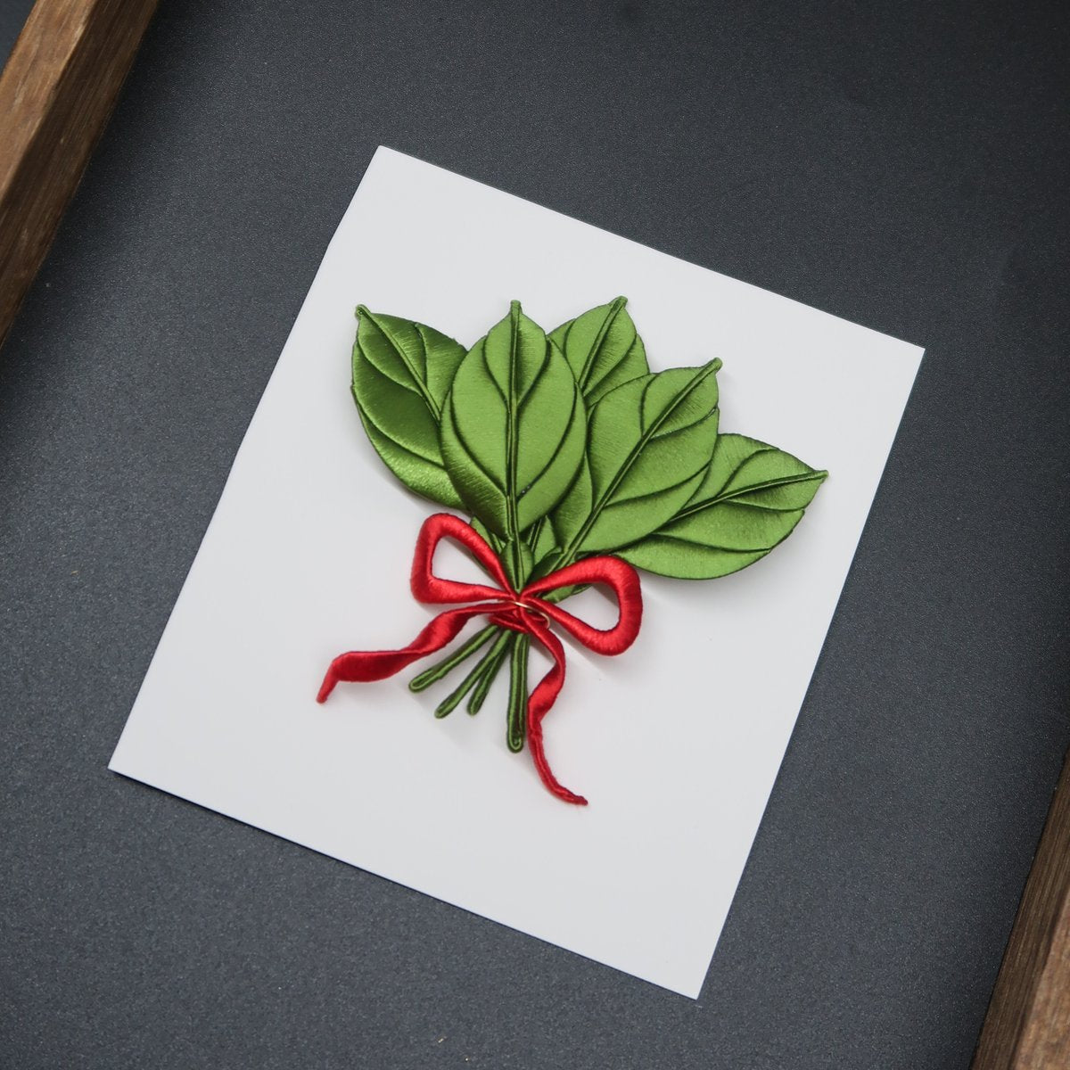 Handmade green thread-wrapped pomelo leaf bouquet hairclip with a red ribbon, a traditional Chanhua craft DIY project for experienced floral artists.