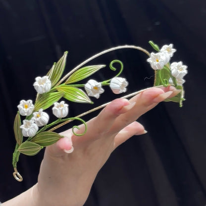 Handmade Lily of the Valley thread-wrapped Chanhua hair crown with white bell flowers and green leaves, an intricate DIY project for experienced floral artists.