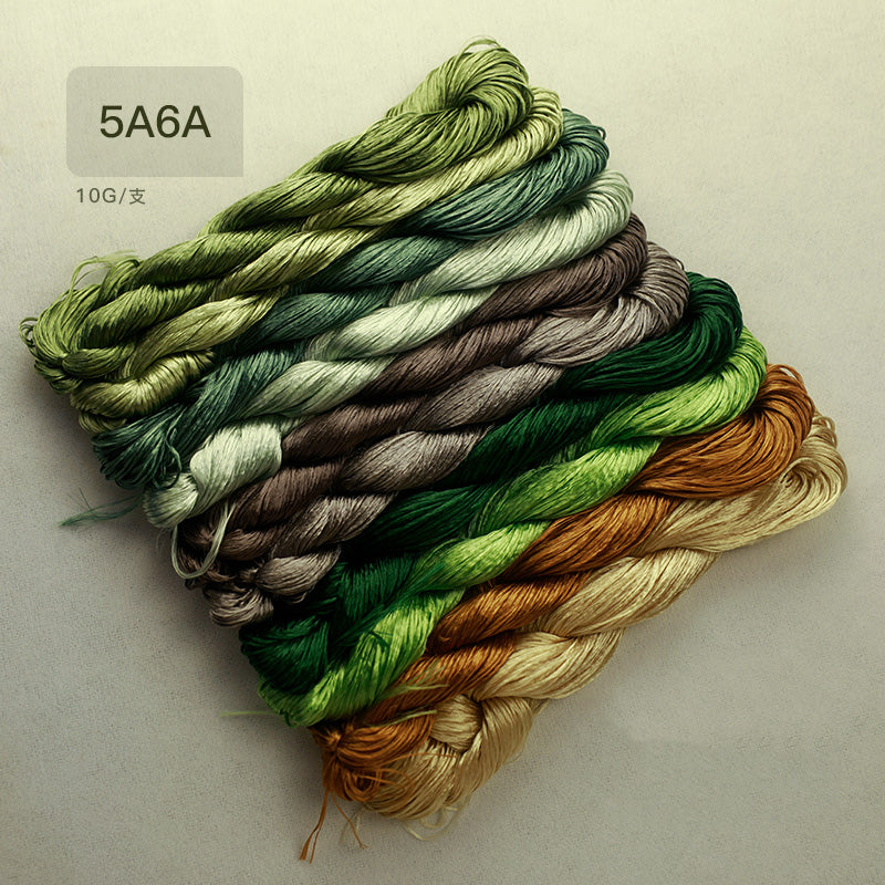 A collection of ten 10g skeins of thick, untwisted mulberry silk thread in a curated palette of leaf colors, ideal for Suzhou embroidery projects.