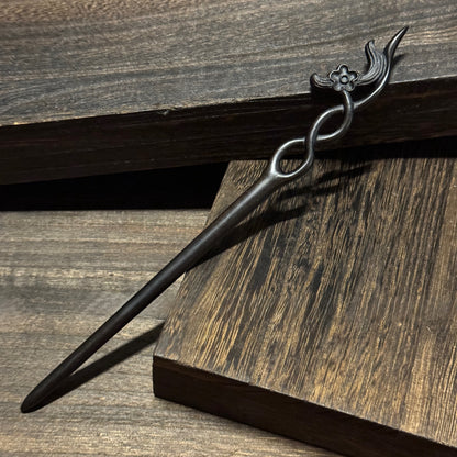 Natural African Blackwood hair stick with 18cm secluded orchid carved design on wooden background.