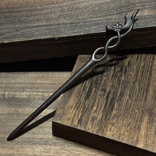 Natural African Blackwood hair stick with 18cm secluded orchid carved design on wooden background.