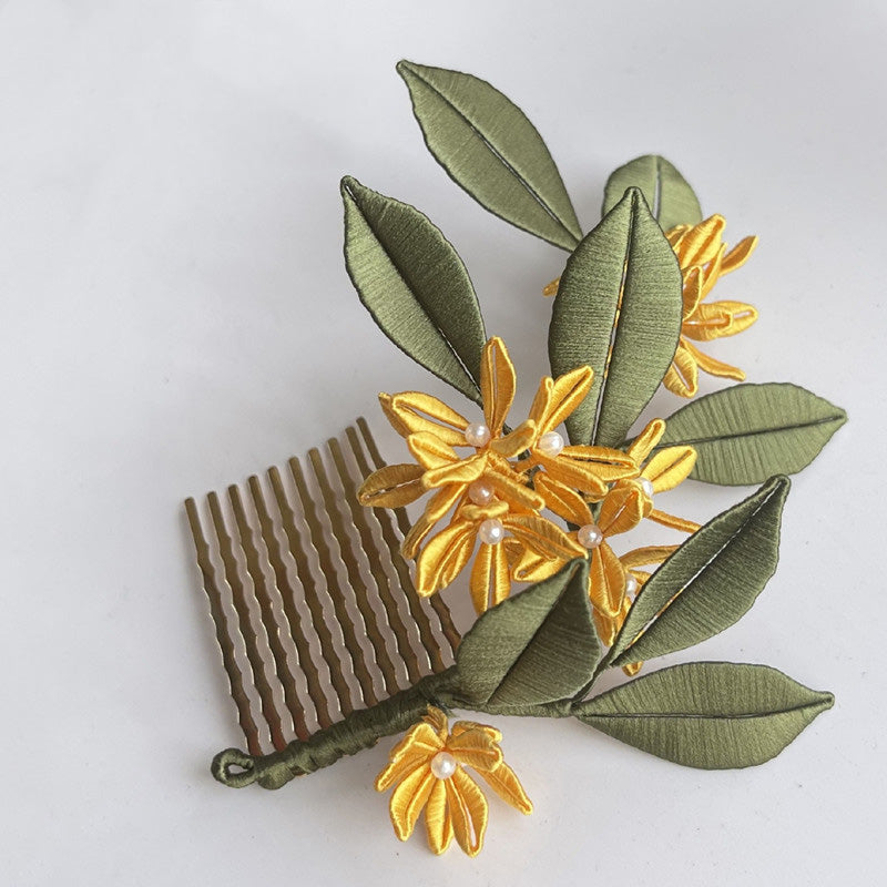 A finished Golden Osmanthus Chanhua hair comb featuring yellow thread-wrapped flowers, green silk leaves, and small pearl accents, attached to a brass-colored comb.