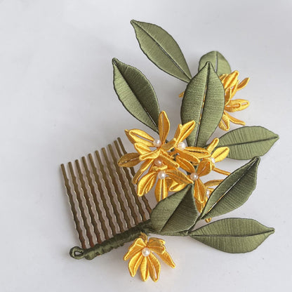 A finished Golden Osmanthus Chanhua hair comb featuring yellow thread-wrapped flowers, green silk leaves, and small pearl accents, attached to a brass-colored comb.