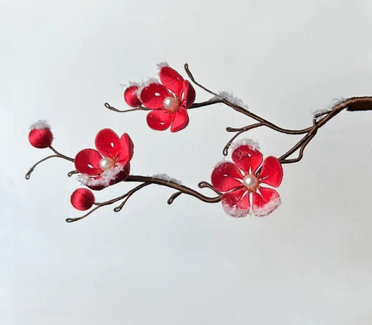 Finished silk-wrapped red Plum Blossom hairpin on a wooden stick with realistic artificial snow details, a handmade DIY flower craft.