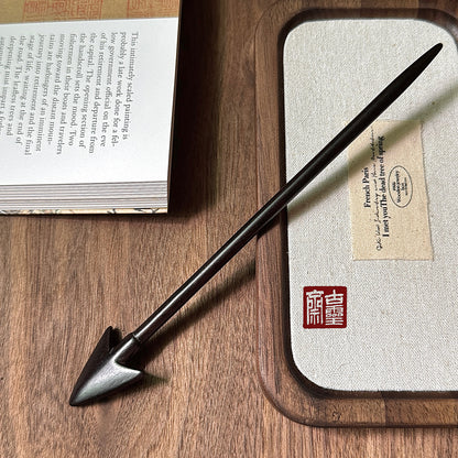 Hand-polished Purple Sandalwood Arrow hair pin with pointed end, shown on a wooden surface next to an open book and boxed item, emphasizing its quality as a DIY hair accessory.