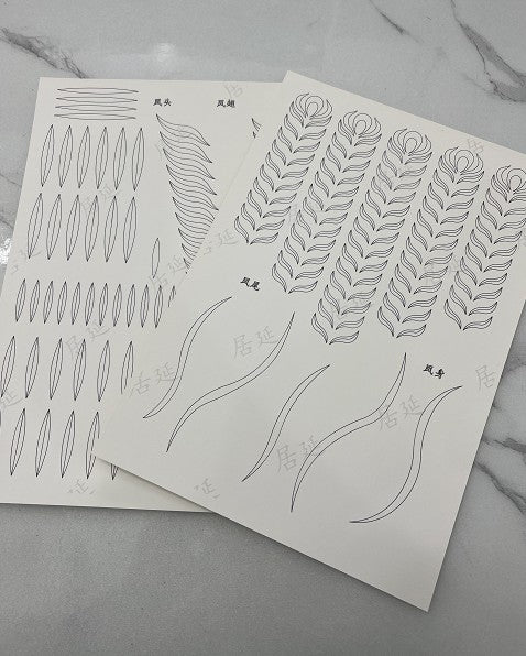 A4 paper sheets with printed templates for crafting a Chinese phoenix, showing outlines for feathers, wings, and body parts.