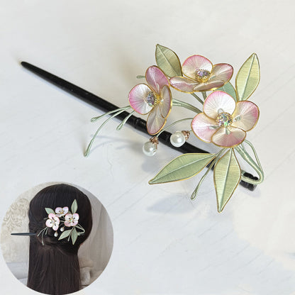 Completed pink Chanhua flower hair stick with light green leaves, shown on a white surface.