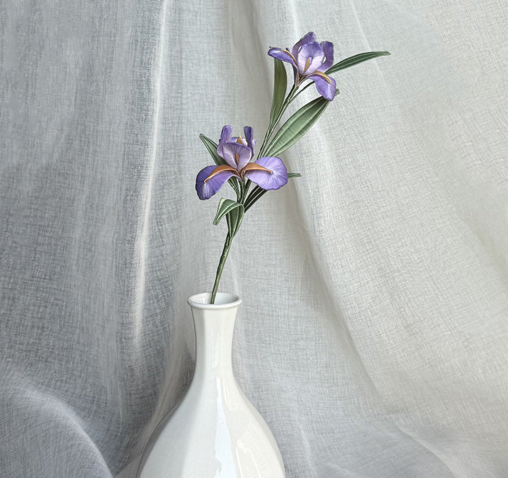 A finished handmade purple Chanhua iris flower with green leaves, created with a DIY craft kit, displayed elegantly in a white vase.