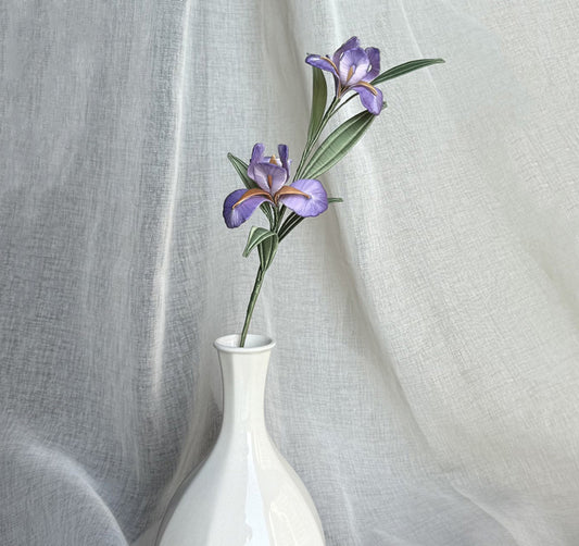 A finished handmade purple Chanhua iris flower with green leaves, created with a DIY craft kit, displayed elegantly in a white vase.