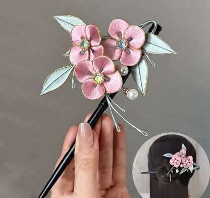Finished pink Chanhua flower hairpin, handmade from a DIY kit, held in a hand.
