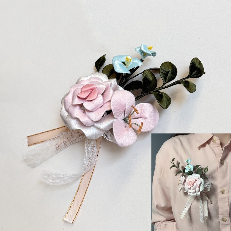 Handmade pink Chanhua rose corsage with light blue accent flowers and ribbons, shown on a model's shirt.