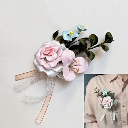 Handmade pink Chanhua rose corsage with light blue accent flowers and ribbons, shown on a model's shirt.