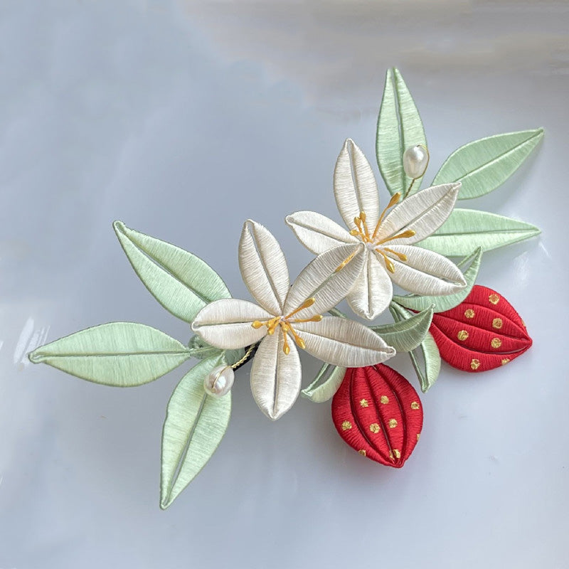 Finished silk-wrapped strawberry flower hairclip with white petals and red fruit accents, a handmade DIY flower craft.
