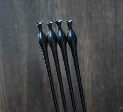 Natural African Blackwood hair stick with vase (flower bottle) design against blurred background.