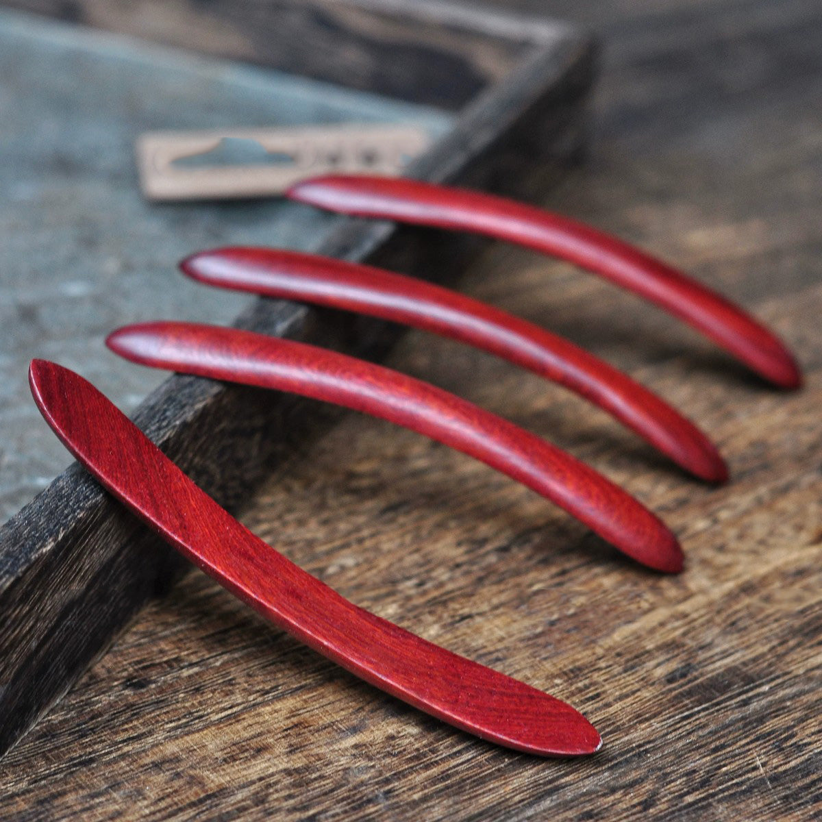 Set of natural African blackwood double prong hair sticks displayed on wooden surface