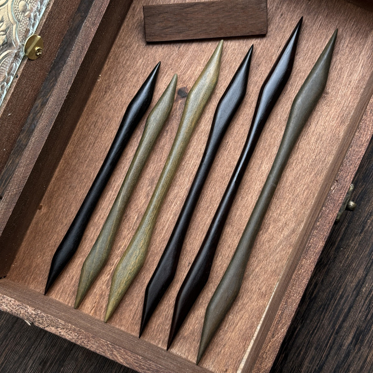 A collection of green sandalwood and blackwood hair sticks in the sleek, 18cm Emei Piercer style, shown together for comparison.