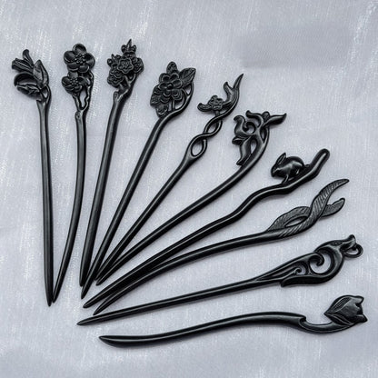 Set of 10 natural African Blackwood hair sticks with carved floral, bird, and animal designs on a light background.