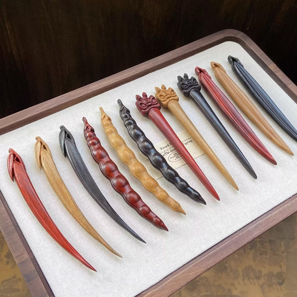 Handmade wooden hair sticks in rosewood, green sandalwood, and ebony displayed on fabric tray