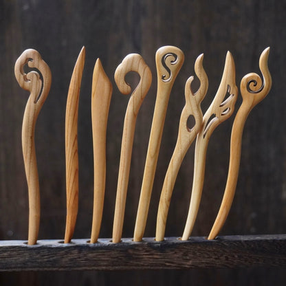 Set of natural peach wood 15cm hair sticks with assorted abstract swirl and flame designs on dark background