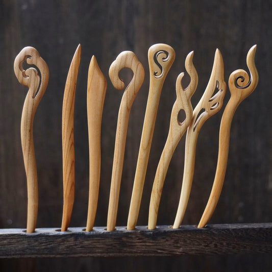 Set of natural peach wood 15cm hair sticks with assorted abstract swirl and flame designs on dark background