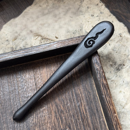 Natural African blackwood hair stick with Lihuo flame carving displayed on wooden tray