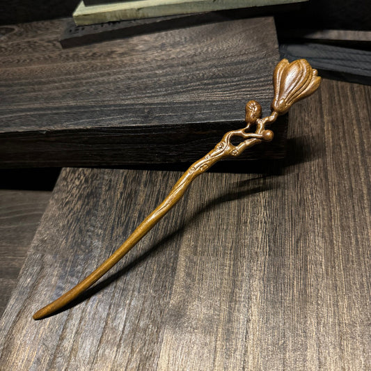 Natural lacewood hair stick with magnolia flower carving 18cm on wooden background.