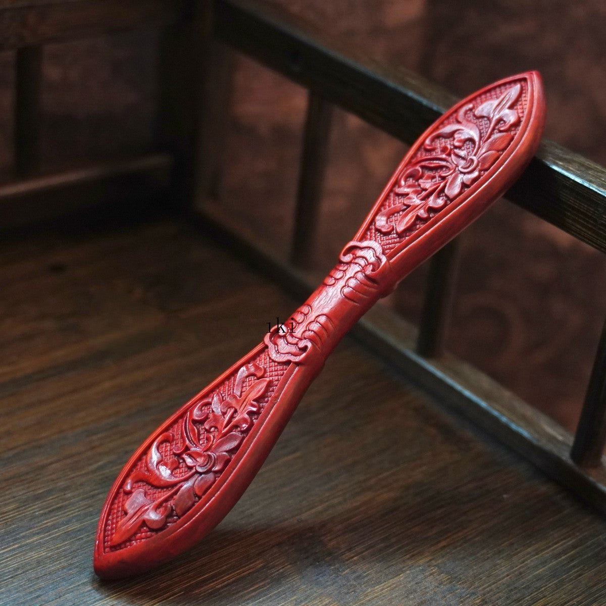 Natural rosewood hair stick with Yanxia Zhi floral carving resting on wooden surface