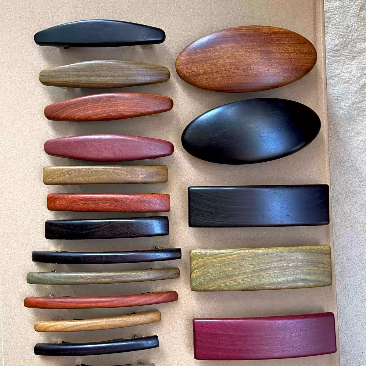 Set of natural wood hair clips showcasing variety in sizes from small bars to large ovals with smooth finish