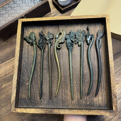 Set of 10 natural Argentine Green Sandalwood hair sticks with carved floral, bird, and animal designs in a wooden box.