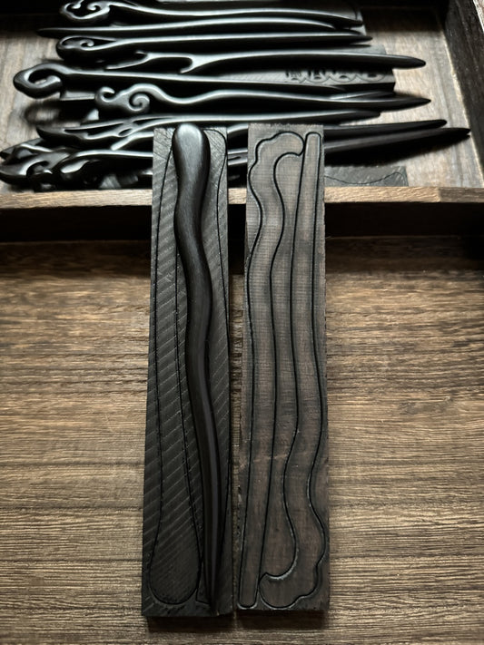 A behind-the-scenes look at the crafting process, showing a finished wavy black sandalwood hairpin next to its carved wooden mold.