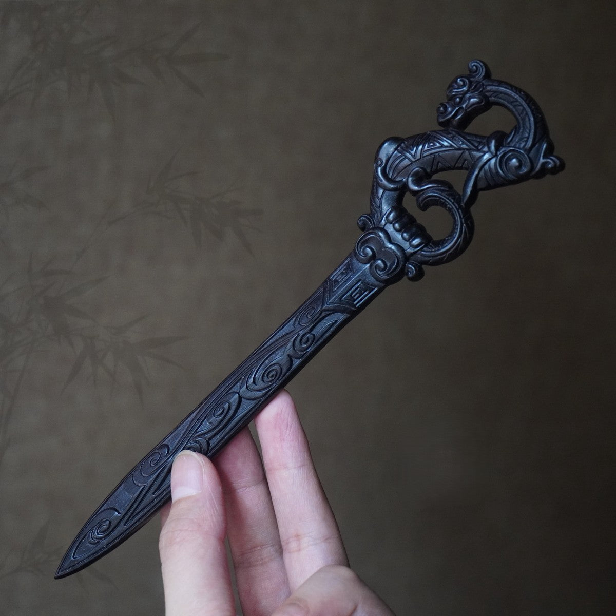 Natural African blackwood 18.8cm hair stick with dragon chant sword design held in hand