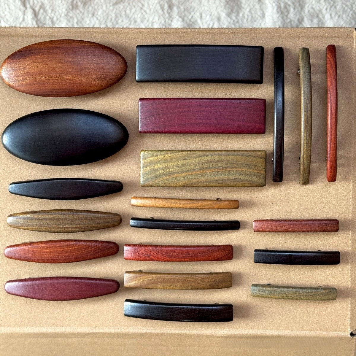 Close-up display of African blackwood and red sandalwood hair accessories highlighting natural grain and color variations