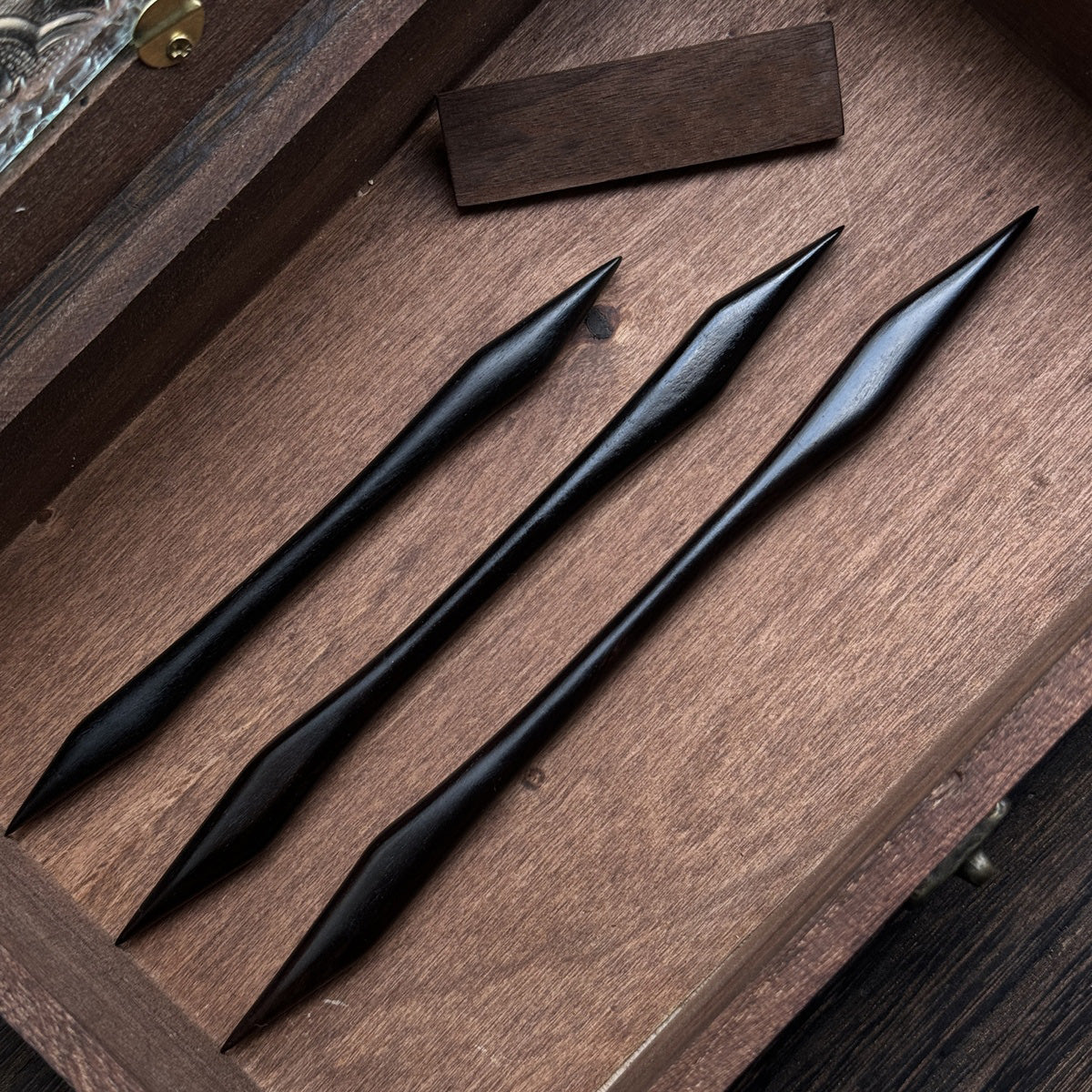 Three hand-polished African Blackwood hair sticks featuring a symmetrical, double-pointed martial arts design, displayed in a row.