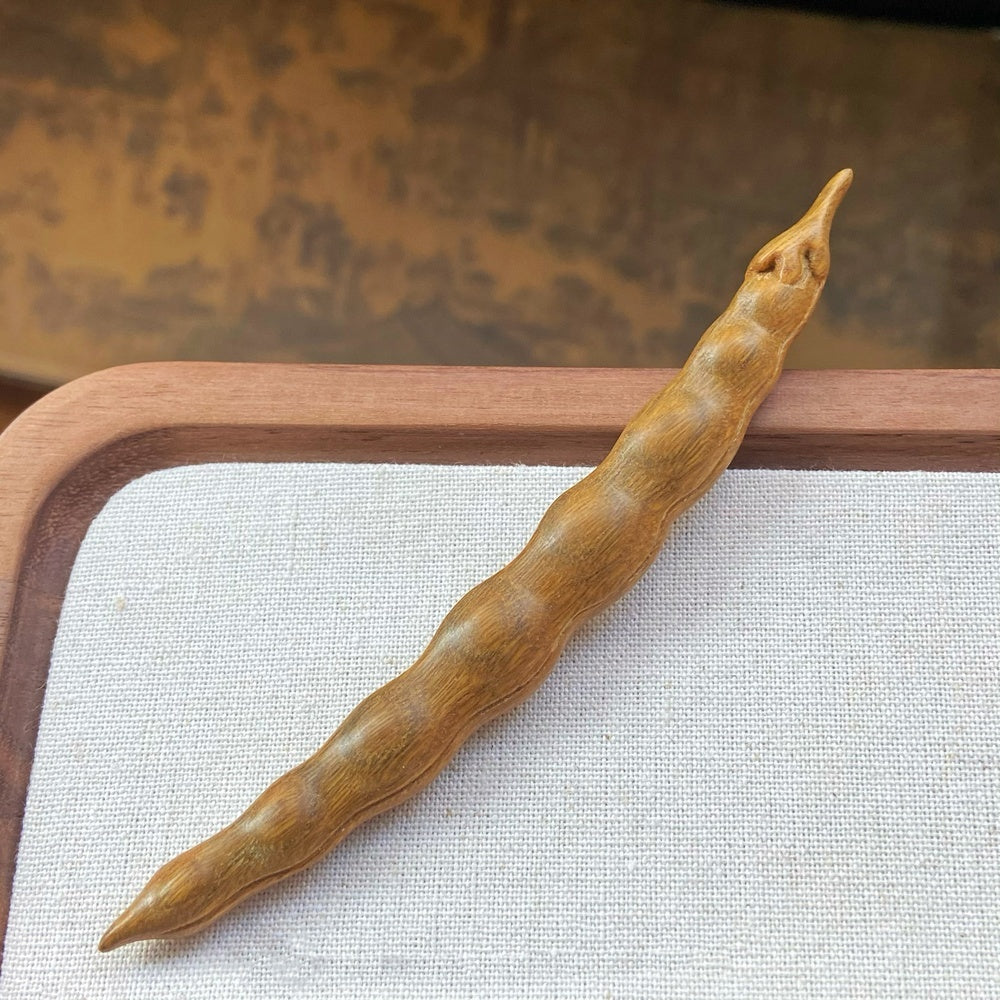 Close-up of yellow-green sandalwood wooden hair stick with smooth finish